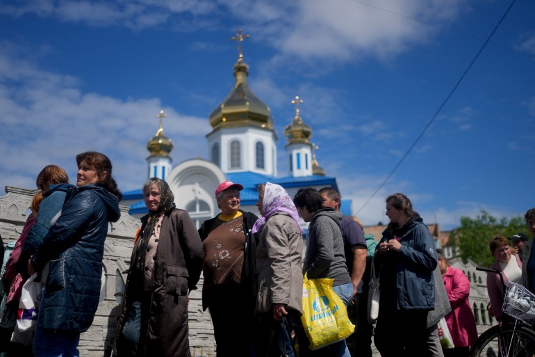 People line up outside a Church to get food and clothing in Borodyanka, on the outskirts of Kyiv, Ukraine, Tuesday, May 31, 2022