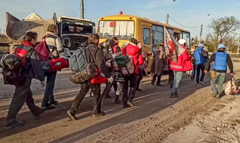 Civilians evacuated from Azovstal escorted to buses by Russian servicemen and Red Cross volunteers