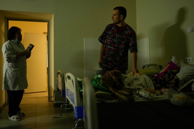 Doctor Ivan Mozhaiev attends to a patient during morning rounds at Pokrovsk hospital.