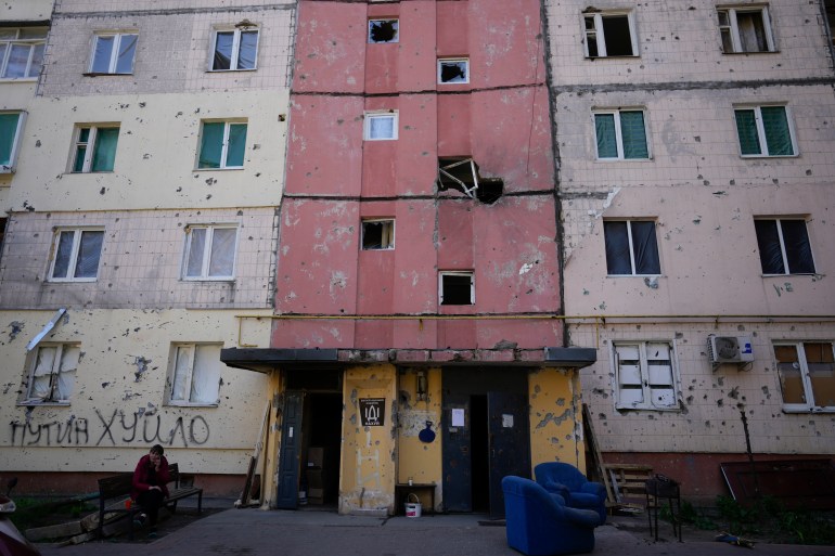 A resident sits outside a house ruined by shelling in Irpin, outskirts of Kyiv, Ukraine, Tuesday, May 24, 2022