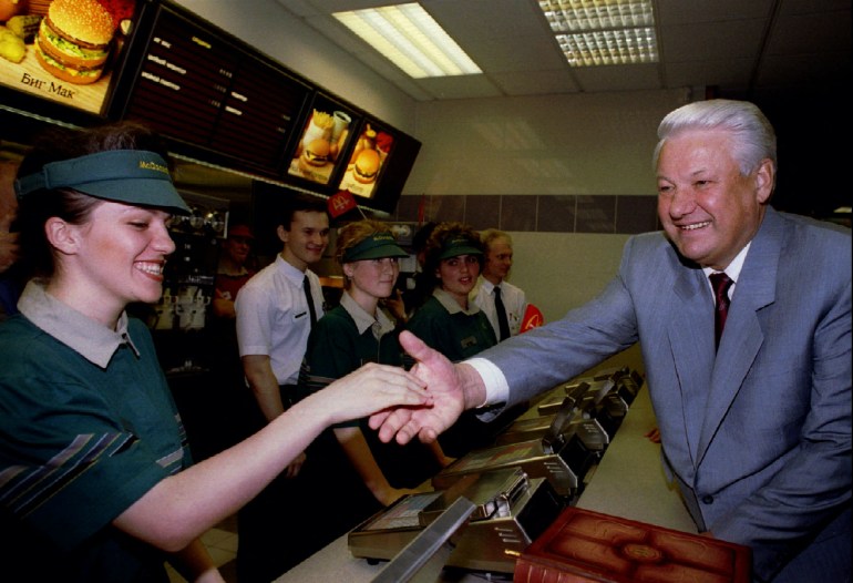 Russian President Boris Yeltsin (R) shakes hands with a staff member at a McDonald's restaurant in Moscow, Russia, 1990