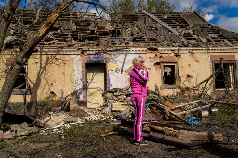 Iryna Martsyniuk, 50, stands next to her house, heavily damaged after a Russian bombing in Velyka Kostromka village, Ukraine.