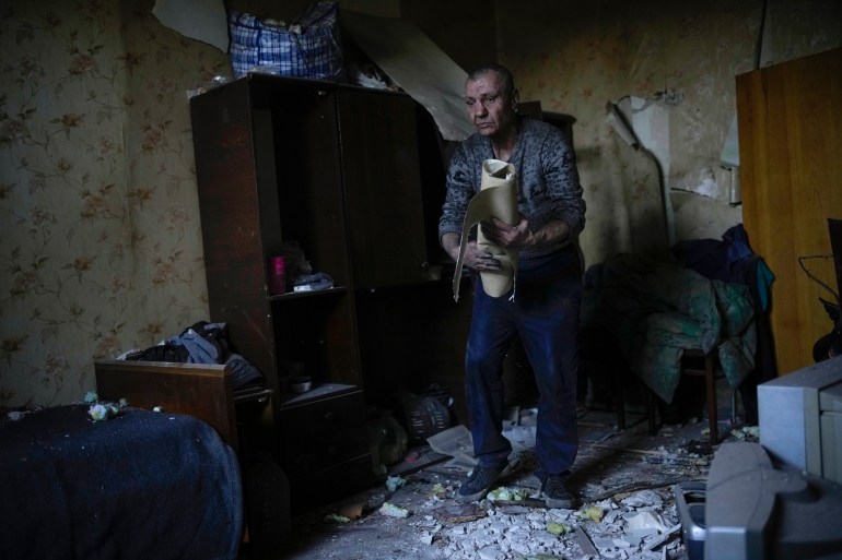 A resident gathers up belongings from his heavily damaged house after a Russian strike in Pokrovske, eastern Ukraine, Wednesday