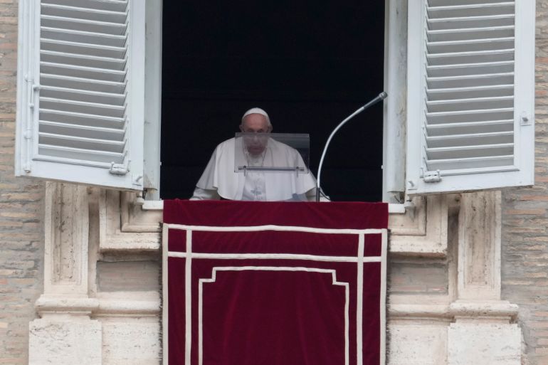Pope Francis reaches his studio window overlooking St. Peter's Square to recite the Regina Coeli prayer at the Vatican, Sunday, May 1, 2022