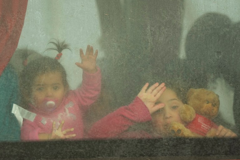 Refugee children look out from a bus leaving to Romania after fleeing the war from neighbouring Ukraine, at the border crossing in Palanca, Moldova, Friday, March 11, 2022