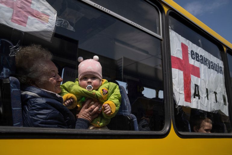 A woman with a child from Siversk look though the window of a bus during evacuation near Lyman.