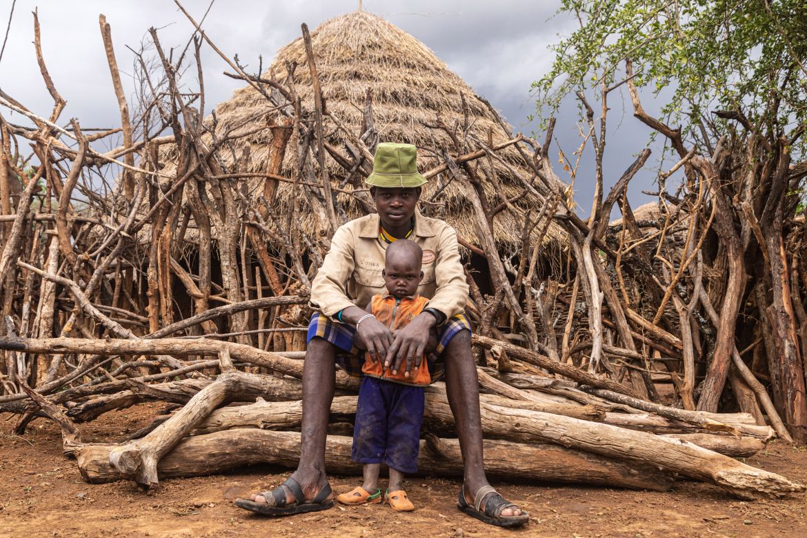A Karamojong man poses with his son in Kotirae, Karamoja region