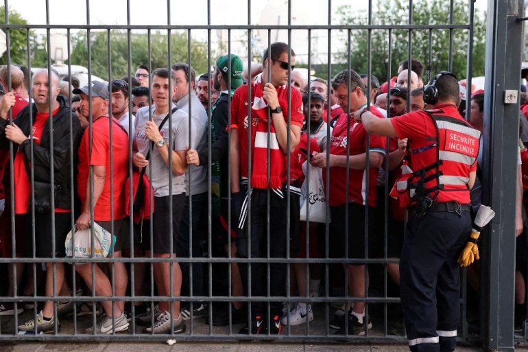 Liverpool fans stand outside the Stade de France, unable to get in in time