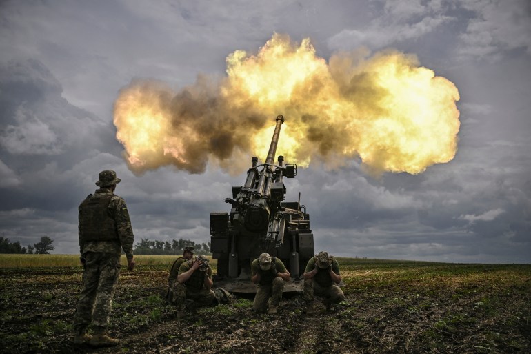 Ukrainian servicemen fire with a French self-propelled 155 mm/52-calibre gun Caesar towards Russian positions at a front line in the eastern Ukrainian region of Donbas on