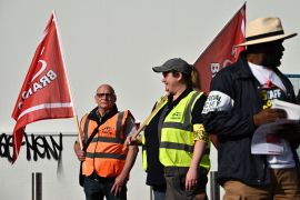 Railway workers hold flags at a picket line