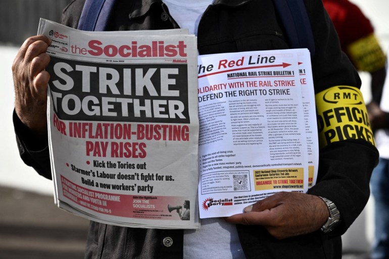 Pamphlets and newspapers are distributed at a picket line outside Waterloo Station in London