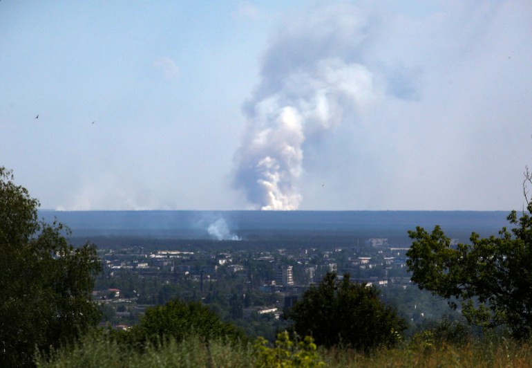 A picture taken on June 21, 2022 from the town of Lysychansk, shows a large plume of smoke rising on the horizon, behind the town of Severodonetsk, amid the Russian invasion of Ukraine. - Regional governor Sergiy Gaiday says that non-stop shelling of Lysychansk on June 20 destroyed 10 residential blocks and a police station, killing at least one person. 