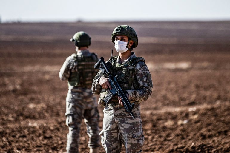 Turkish soldiers stand guard during a joint Russian-Turkish patrol in the eastern countryside of the town of Darbasiyah near the border with Turkey