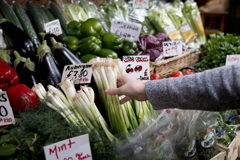 Labels show the price in pounds sterling (GBP) of fruit and vegetables displayed for sale at a market stall in Borough, central London