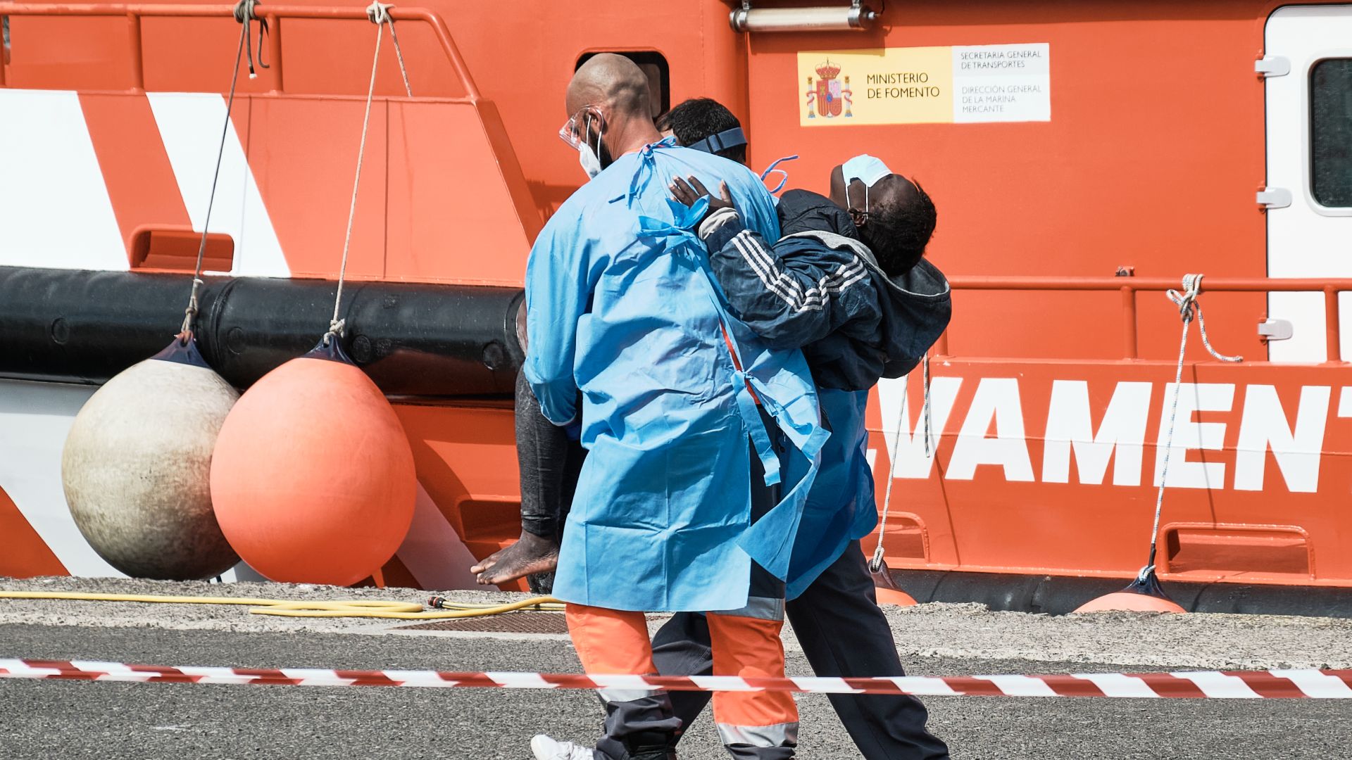 A photo of a woman being helped by Red Cross staff after a rescue vessel came ashore in Arguineguin, Gran Canaria.