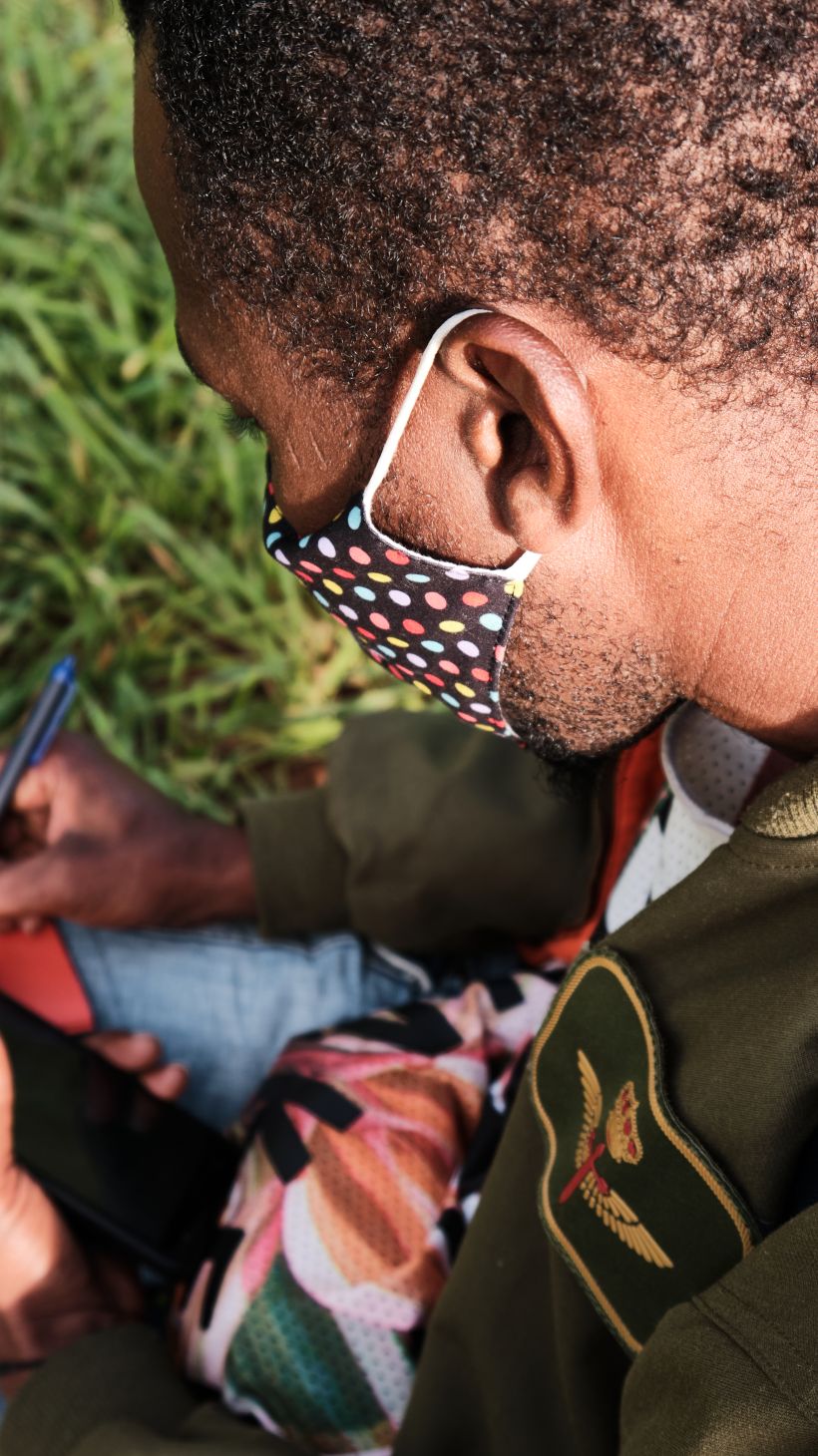 A photo of Mamadou, 28, from Mali, writing a note in Pular