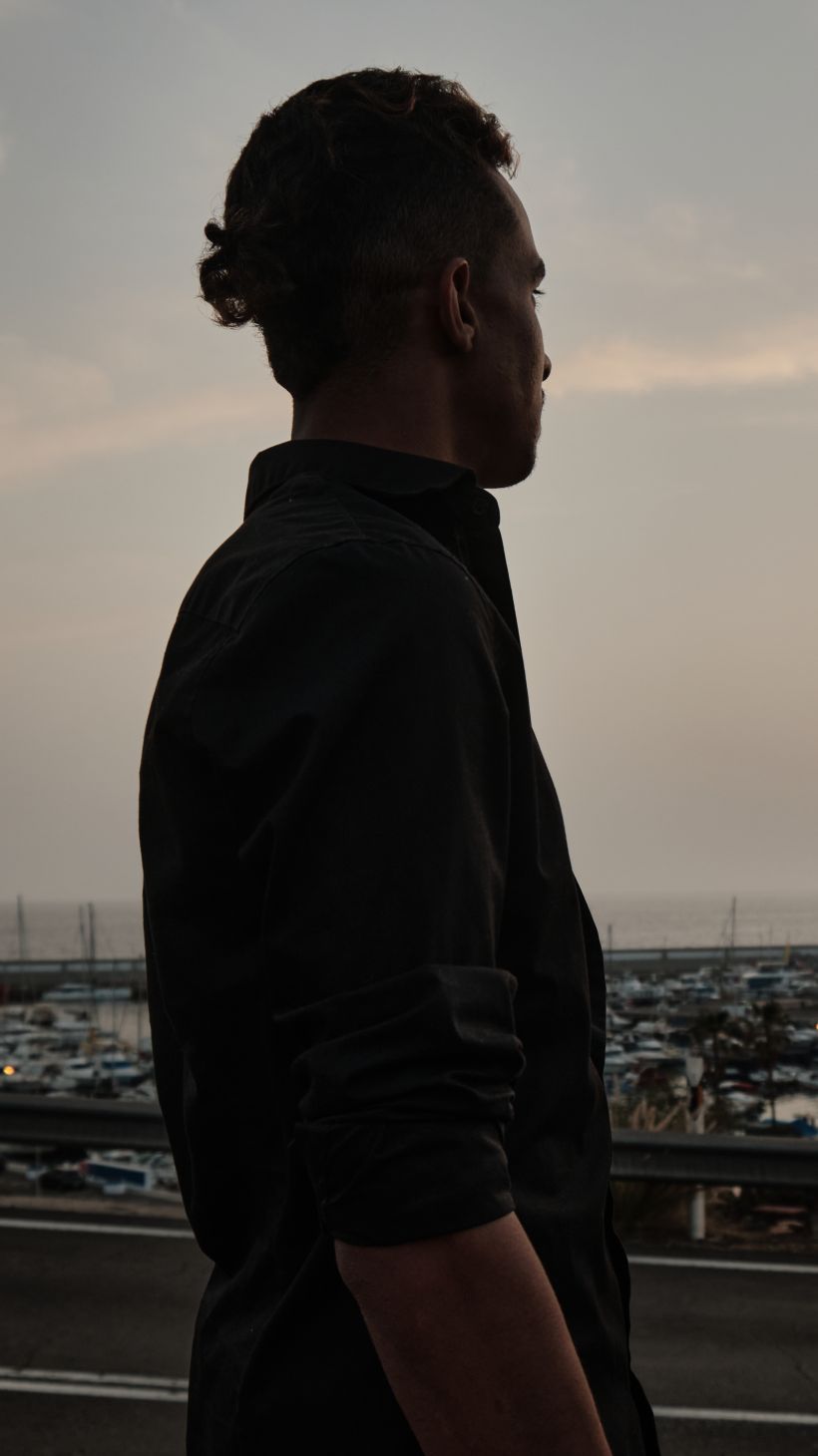 A photo of Youssef, 23, from Morocco, overlooks the little harbour of Puerto Rico, in Gran Canaria.