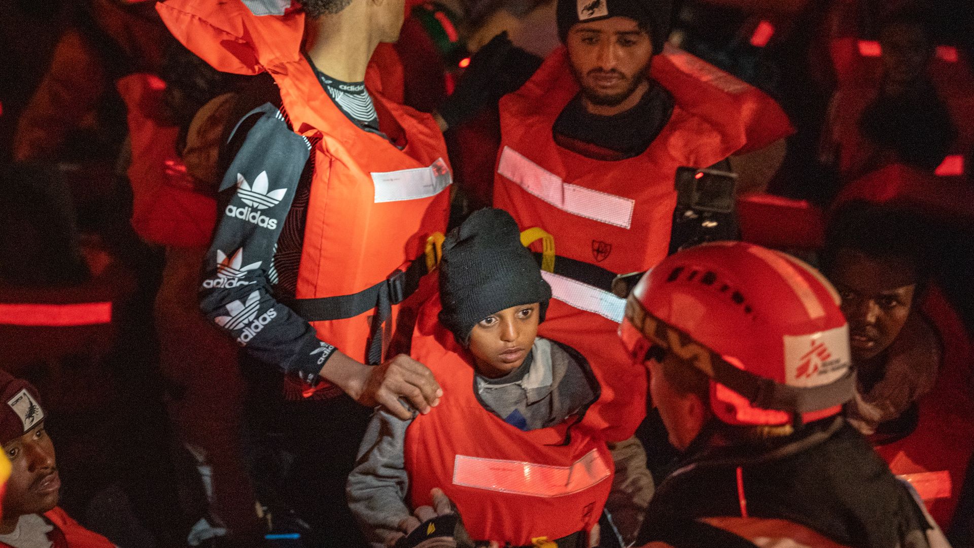 Search and rescue team helping survivors on a boat in the Med Sea