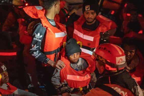 Search and rescue team helping survivors on a boat in the Med Sea