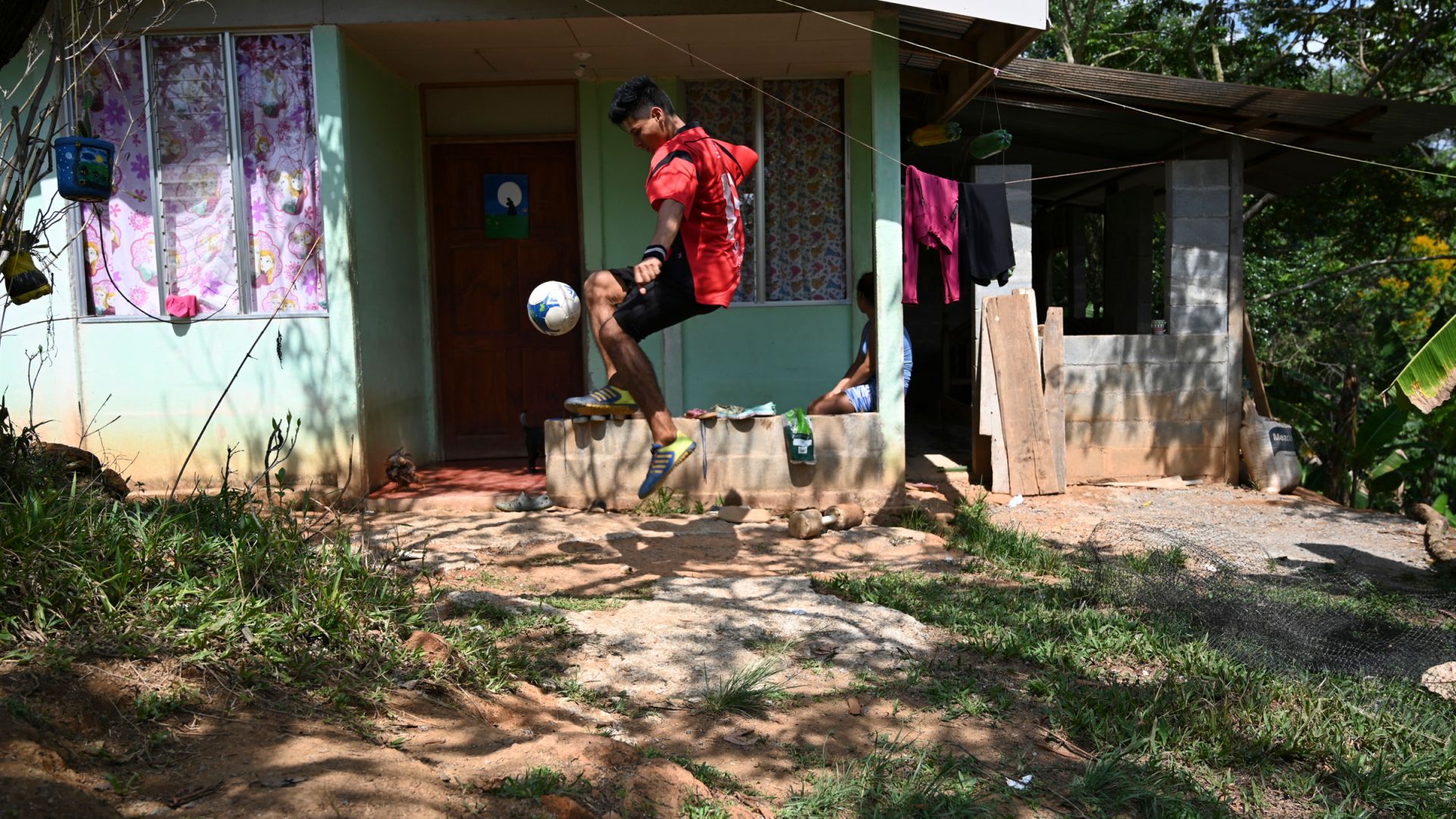 A photo of Junior Jara, 22, a student from Salitre, playing football outside his new home.