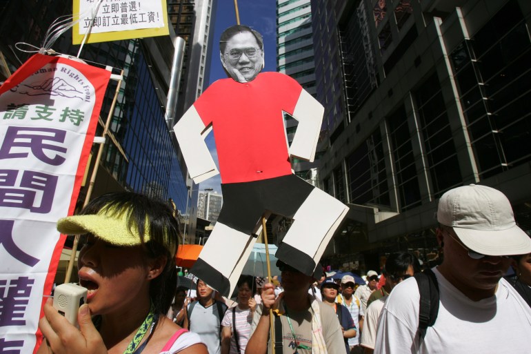 A protester carries an effigy of Hong Kong Chief Executive Donald Tsang as tens of thousands of people take part in a democracy march in Hong Kong