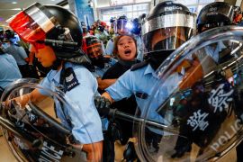Riot police detain a woman during protests in Hong Kong, China.