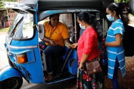A passenger pays Lasanda Deepthi, 43, an auto-rickshaw driver for local ride hailing app PickMe, after they got dropped off at their destination in Gonapola town
