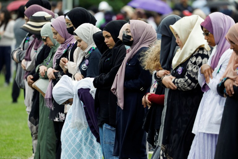 Women pray ahead of an event marking the one-year anniversary of a deadly attack on a Muslim family in London, Ontario