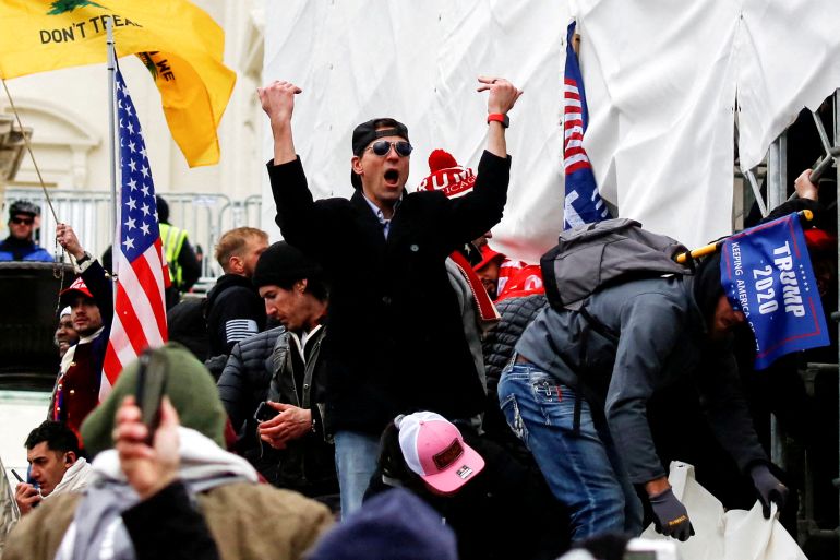 A man, identified as Ryan Kelley in a sworn statement by an FBI agent, gestures as supporters of U.S. President Donald Trump make their way past barriers at the US Capitol