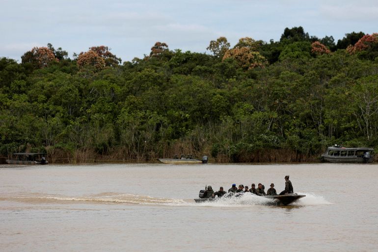 Brazilian soldiers sit in a boat during the search for Dom Phillips and Bruno Pereira