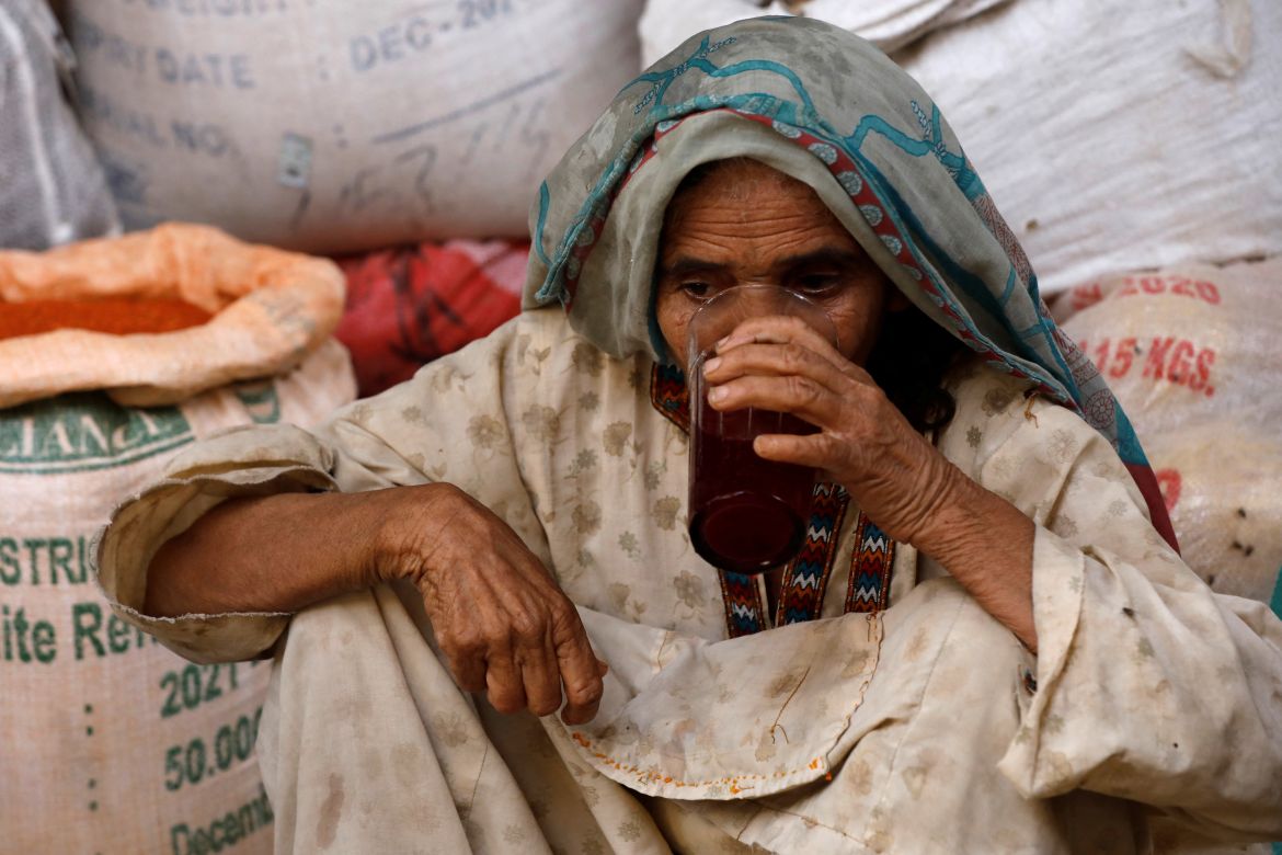 A woman drinks a plum and tamarind drink to cool off during a heatwave, in Jacobabad