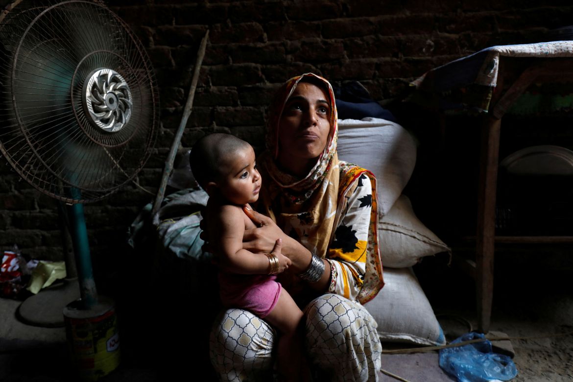 Razia, 25, and her six-month-old daughter Tamanna, sit in front of a fan to cool off