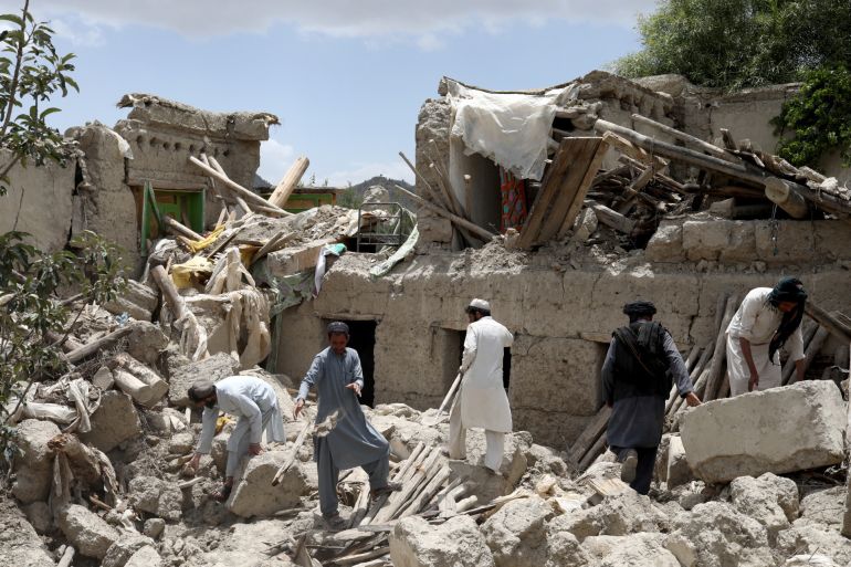 Afghan men search for survivors amidst the debris of a house that was destroyed by an earthquake in Gayan, Afghanistan, June 23, 2022
