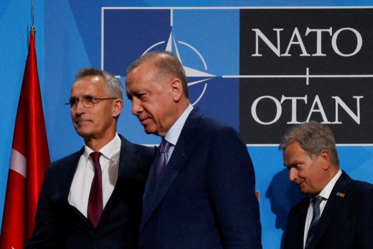 Turkish President Tayyip Erdogan, NATO Secretary General Jens Stoltenberg and Finland's President Sauli Niinisto leave after signing a document during a NATO summit in Madrid.