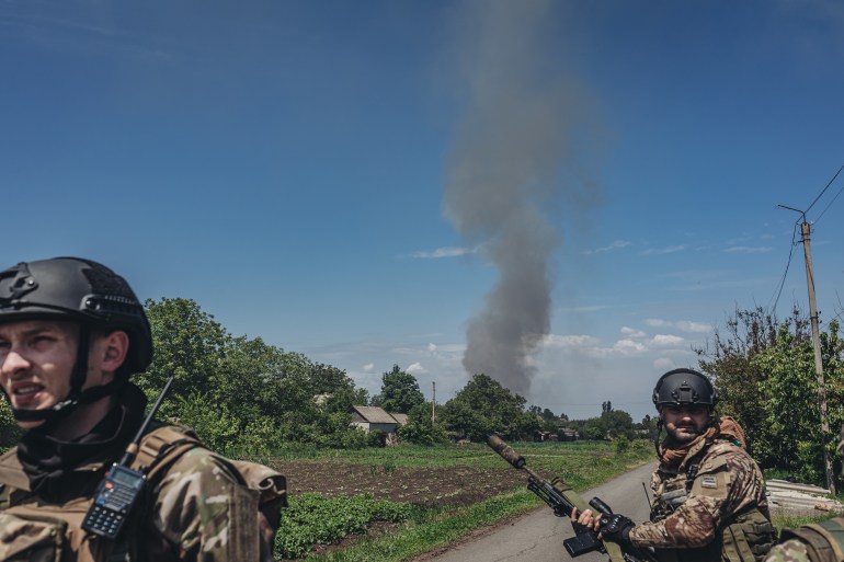 A photo of two soldiers walking in front of a Russian missile fire.