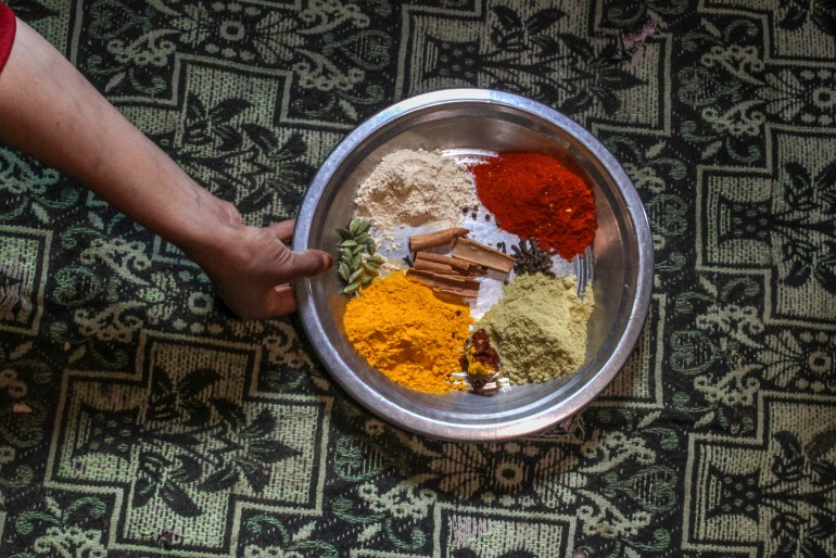An overhead view of a metal dish holding piles of spices,