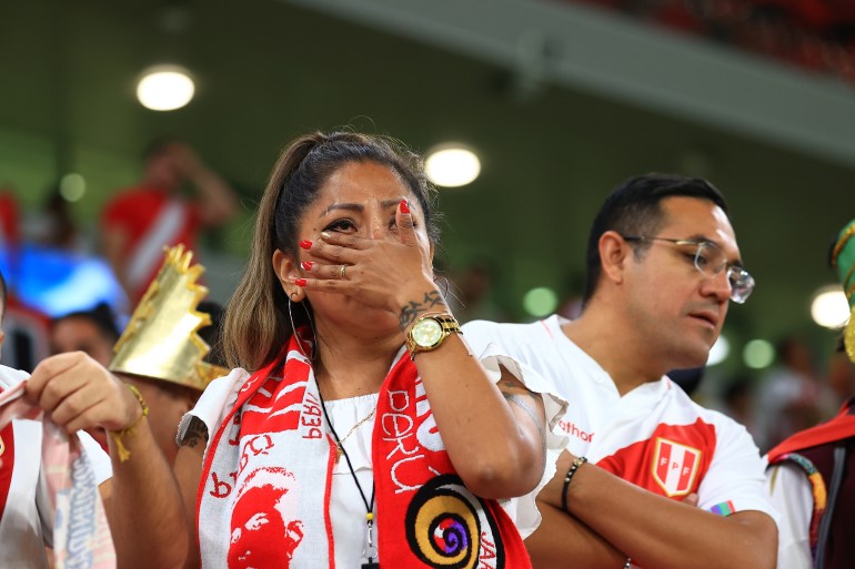 A female Peru supporter wipes tears away.