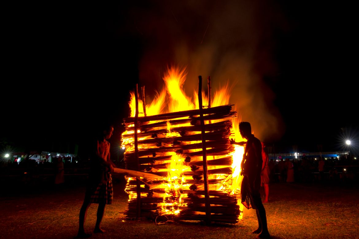 Indian Rabha tribal Hindu priests burn wood during Baikho festival