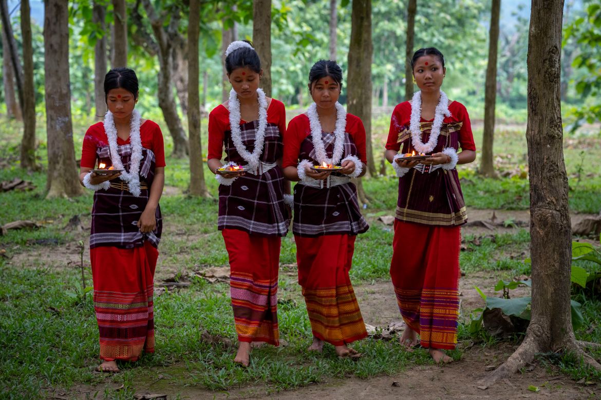 Indian Rabha tribal girls in traditional attire bring offerings before they perform a tribal Rabha dance