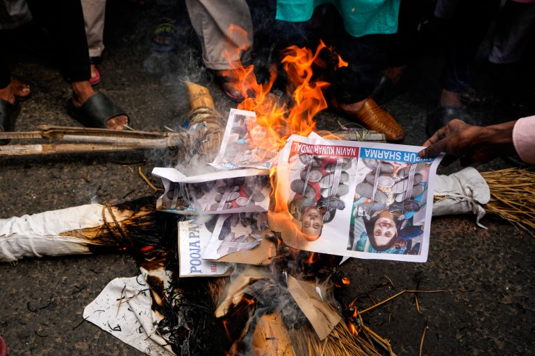 Indian Muslims burn an effigy with portraits of BJP leader Nupur Sharma.