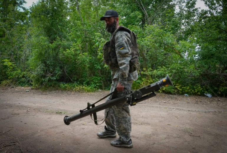 A Ukrainian soldier carries a U.S.-supplied Stinger as he goes along the road, in Ukraine's eastern Donetsk region 