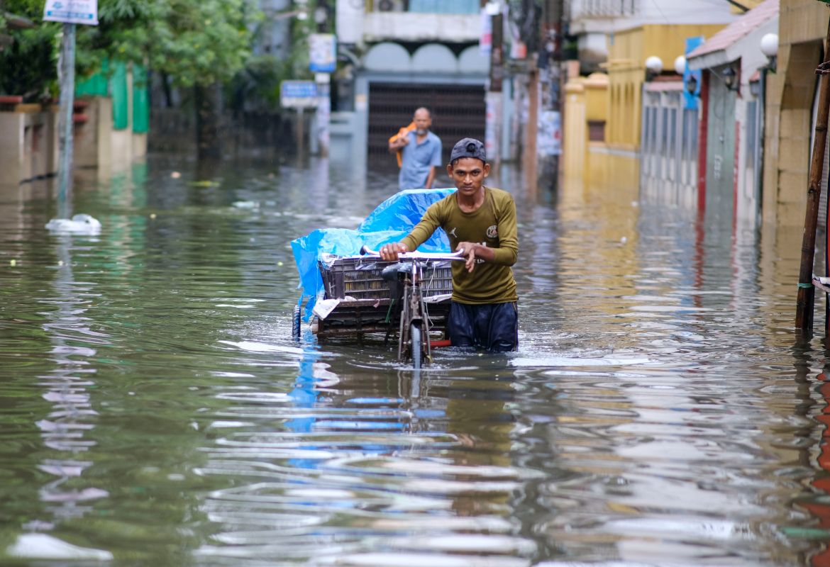 A man pushes his cart through floodwaters