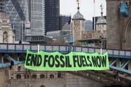Climate change activists hang a sign on Tower Bridge during a demonstration