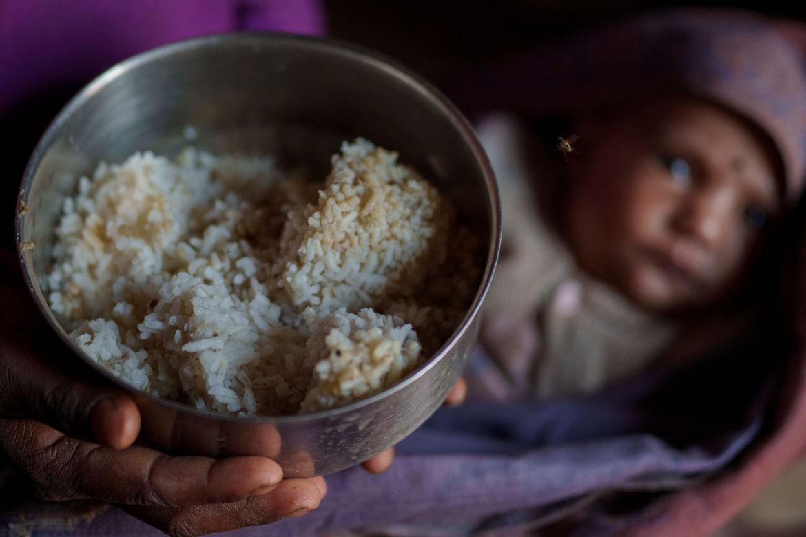 A woman shows the food which is only rice and salt that she feed to her children in Muktikot