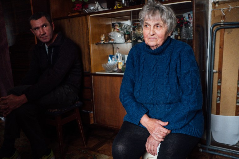 A photo of Nikolay Masanovec (left) and Nadia Masonovec (right) in a room with a shelf behind them.