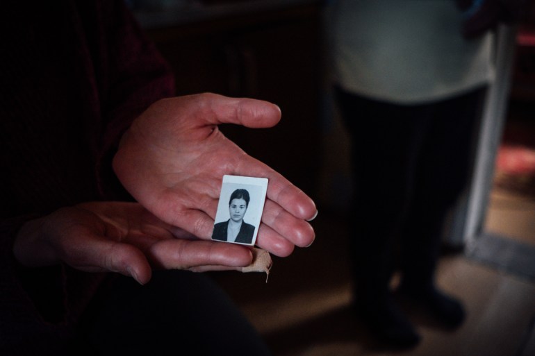 A photo of someone holding an old passport photo of Olesya Masonovec.