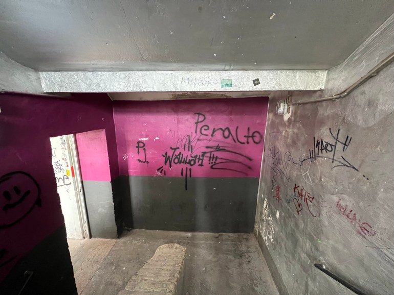 Exhibition space vandalized and with writings on the walls