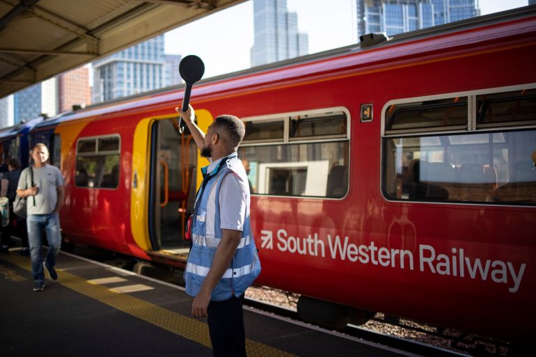 A platform staff member works whilst people travel ahead of national rail strikes at Vauxhall station in London, Britain, 20 June 2022. More than half of the UK's rail network will be suspended next week during three days of rail strikes.