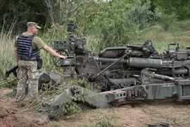 A Ukrainian soldier stands at a US-supplied M777 howitzer in Ukraine's eastern Donetsk region Saturday, June 18, 2022
