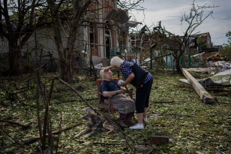 Elena Holovko is attended to as she sits outside her home, damaged by a Russian missile strike, in Druzhkivka in eastern Ukraine, Sunday, June 5, 2022 